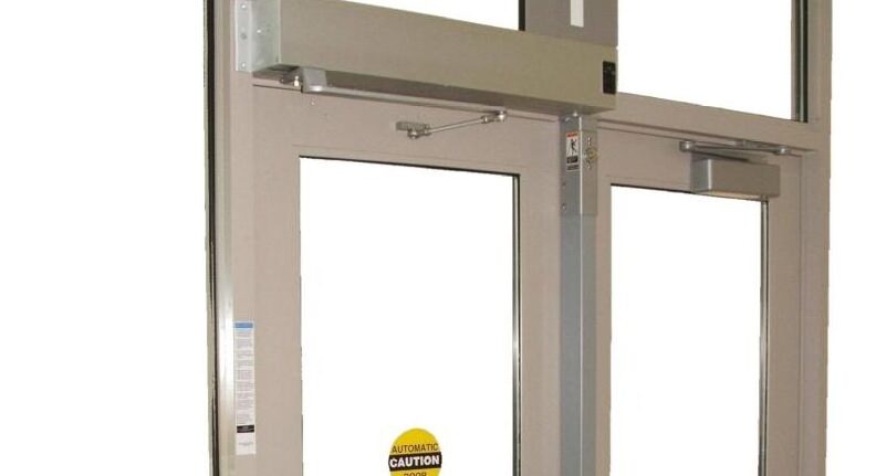 Automatic glass doors with caution sign in a commercial building entryway.